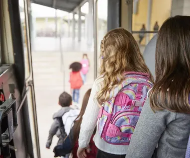 uczniowie wysiadają z wynajętego autobusu na wycieczkę szkolną